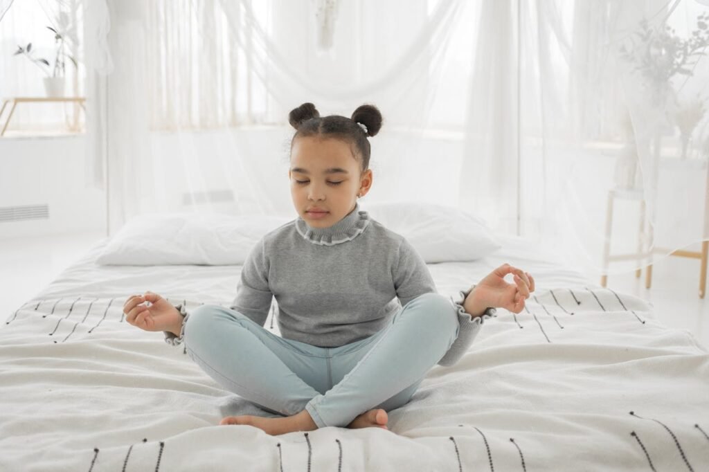 A young girl practicing yoga on her bed, surrounded by a calm and cozy atmosphere.