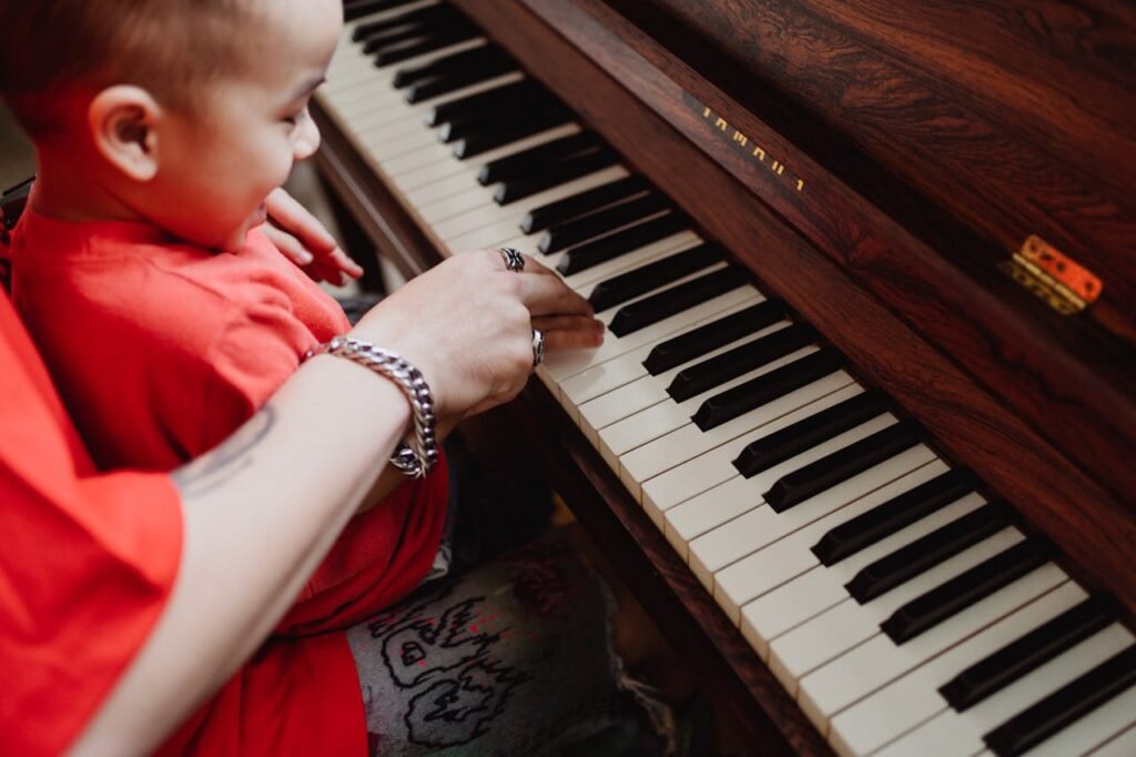 mother holding a baby playing a piano.