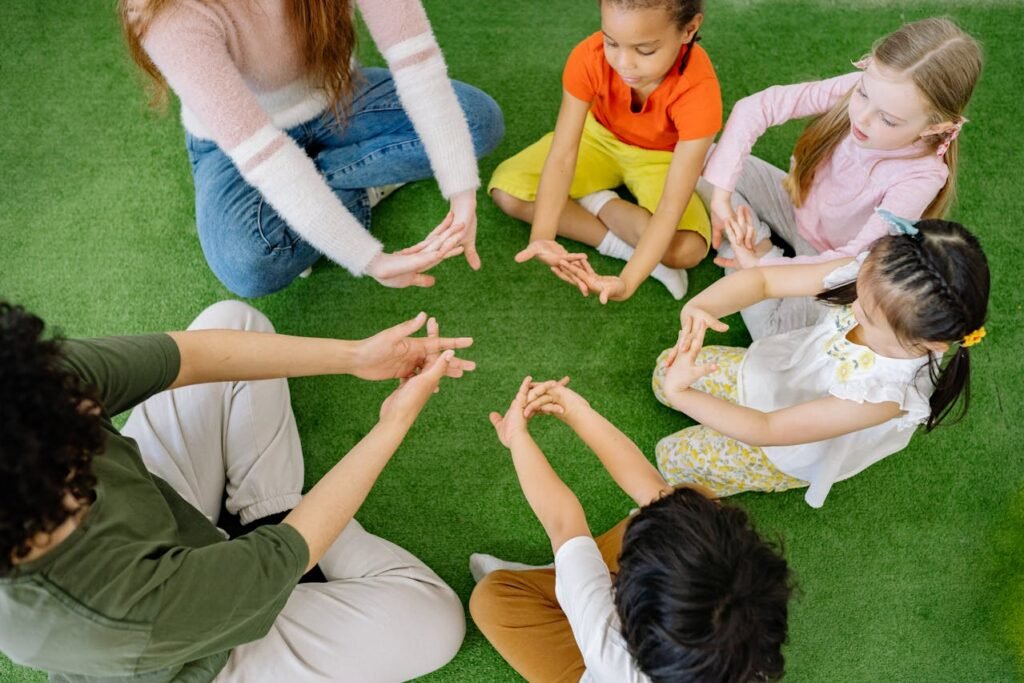 Children sitting in a circle with a teachers, engaged in a fun and interactive learning activity together.