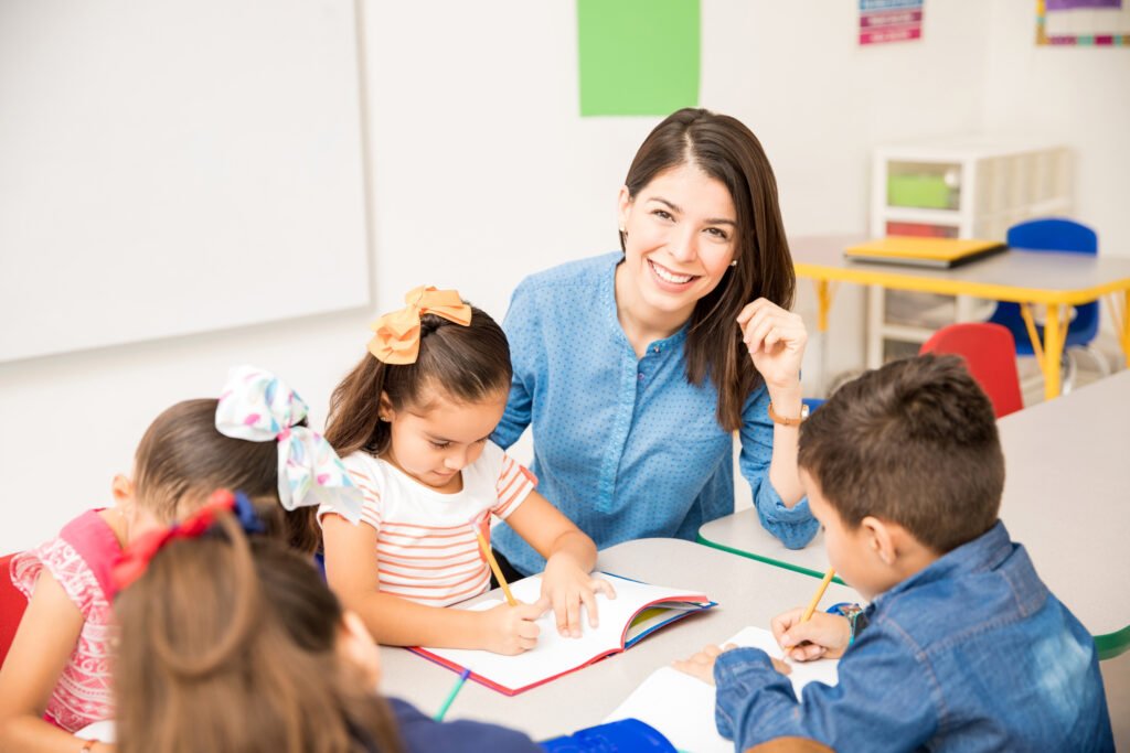 preschool teacher teaching her students in a classroom.