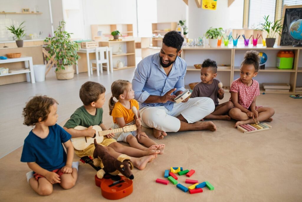 children sitting on the floor with teacher and playing instruments.